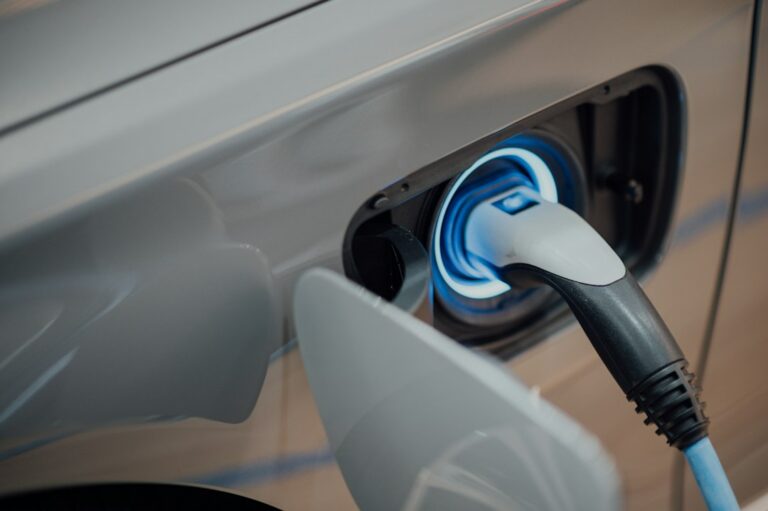 electric vehicle charger plugged into car — illustrative photo for electric vehicle battery and charging